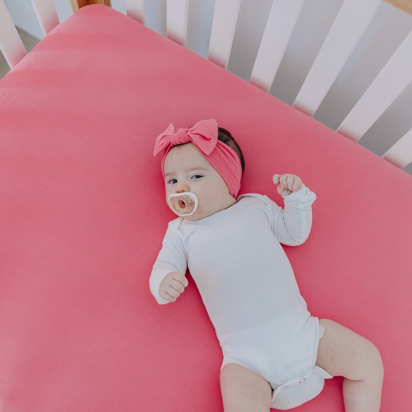 Copper Pearl premium knit fitted crib sheet featuring a flamingo pattern, soft and snug for baby cribs.