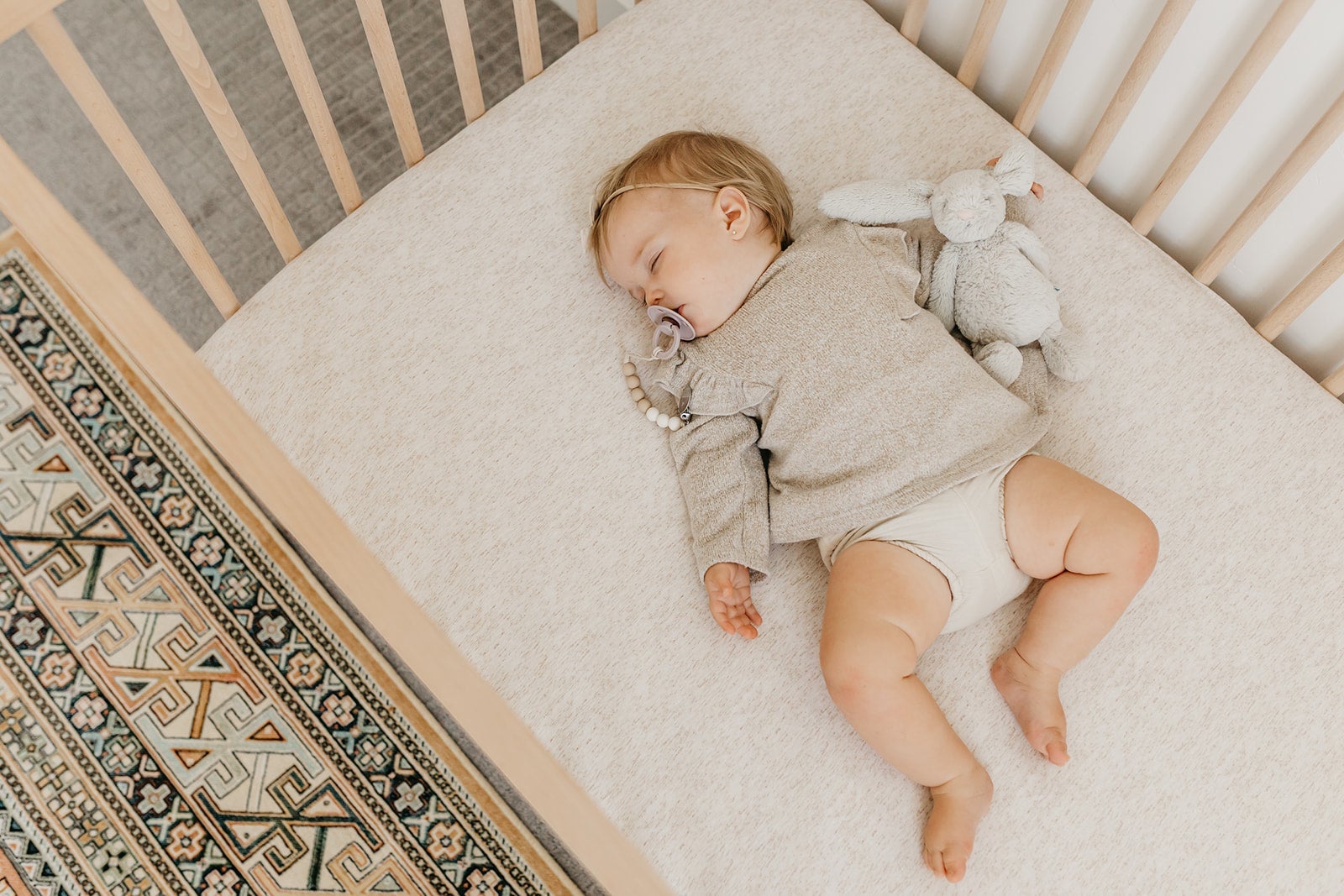 Copper Pearl premium knit fitted crib sheet in oat color, soft and stretchy fabric, designed for a secure fit on a crib mattress.