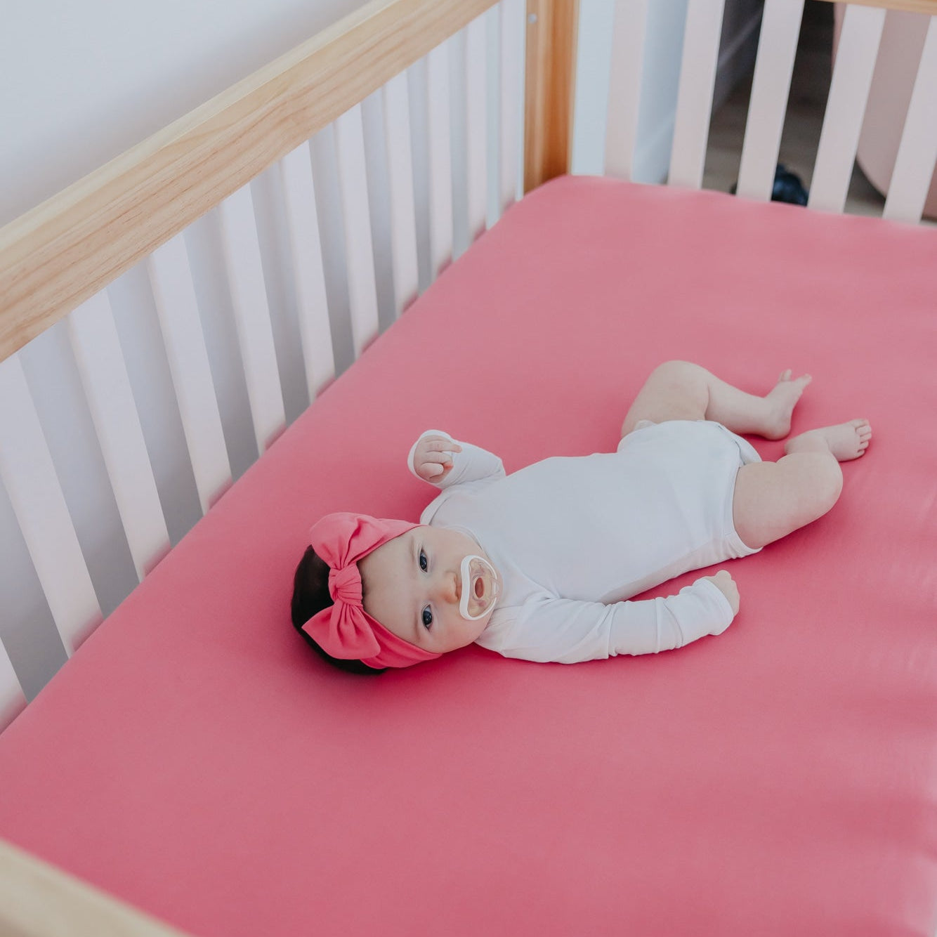 Copper Pearl premium knit fitted crib sheet featuring a flamingo pattern, soft and snug for a baby’s crib.