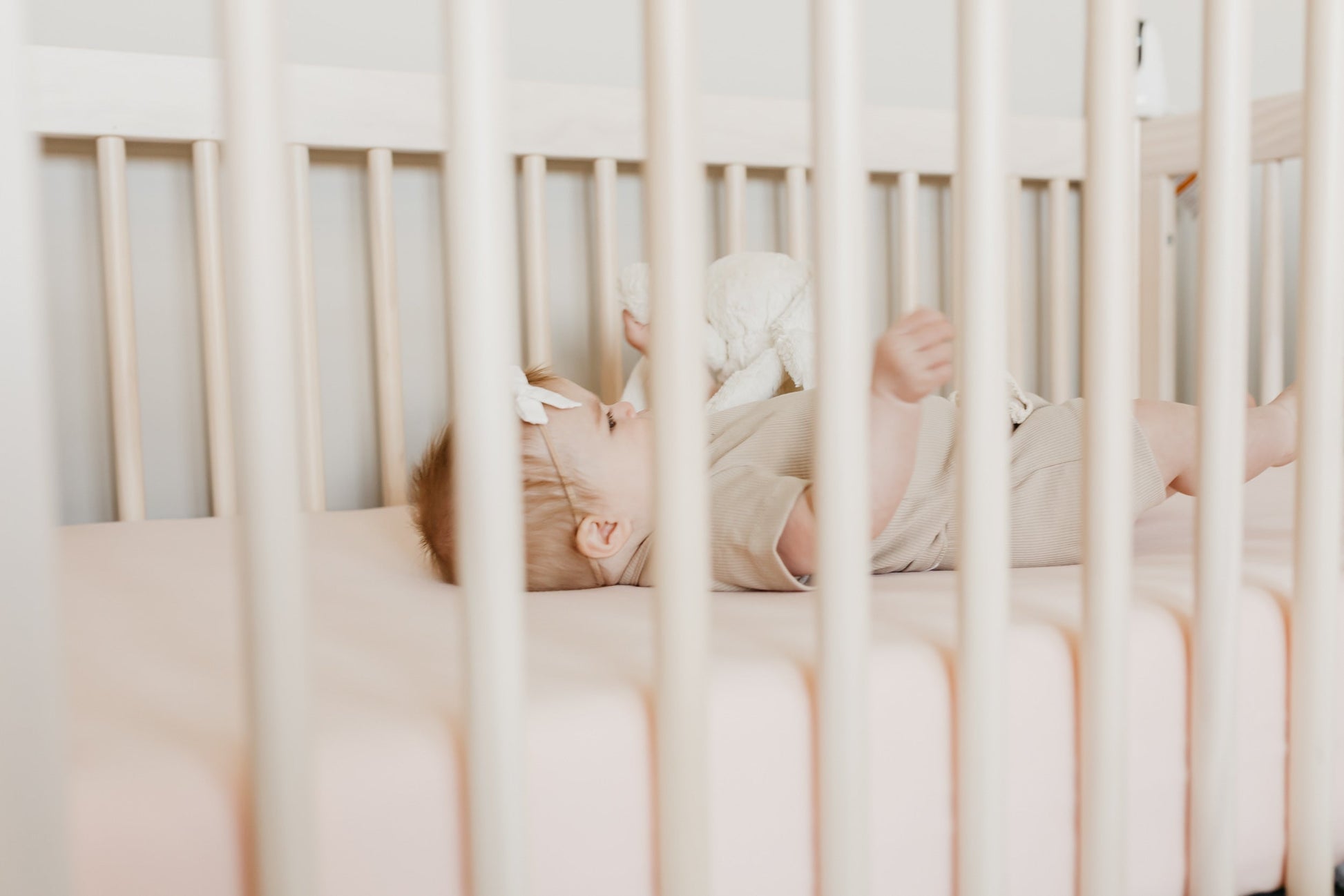 Copper Pearl premium knit fitted crib sheet in blush color, featuring soft, cozy fabric and elastic edges for a snug fit.