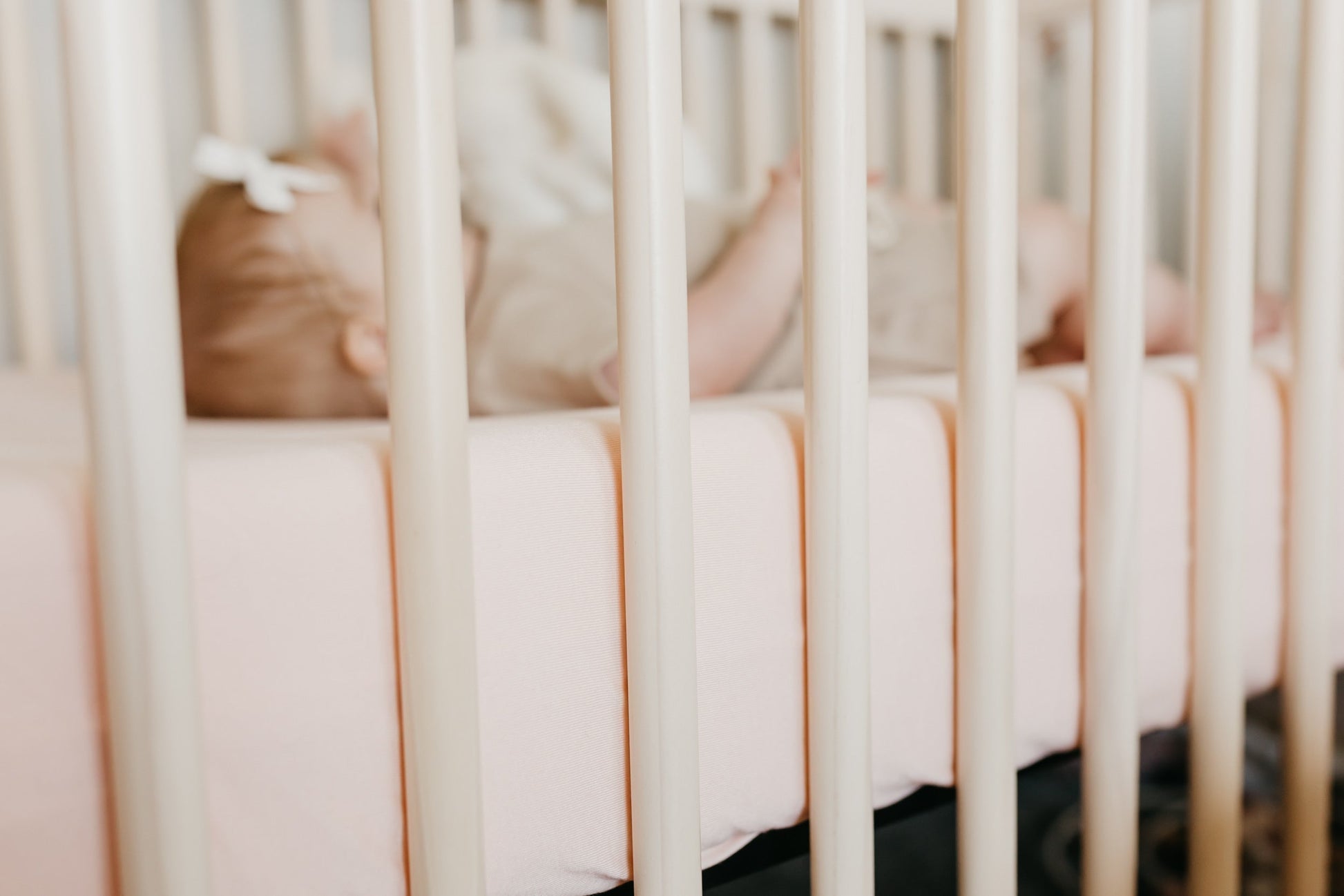 Copper Pearl premium knit fitted crib sheet in blush color with soft, stretchy fabric perfect for cozy baby bedding.