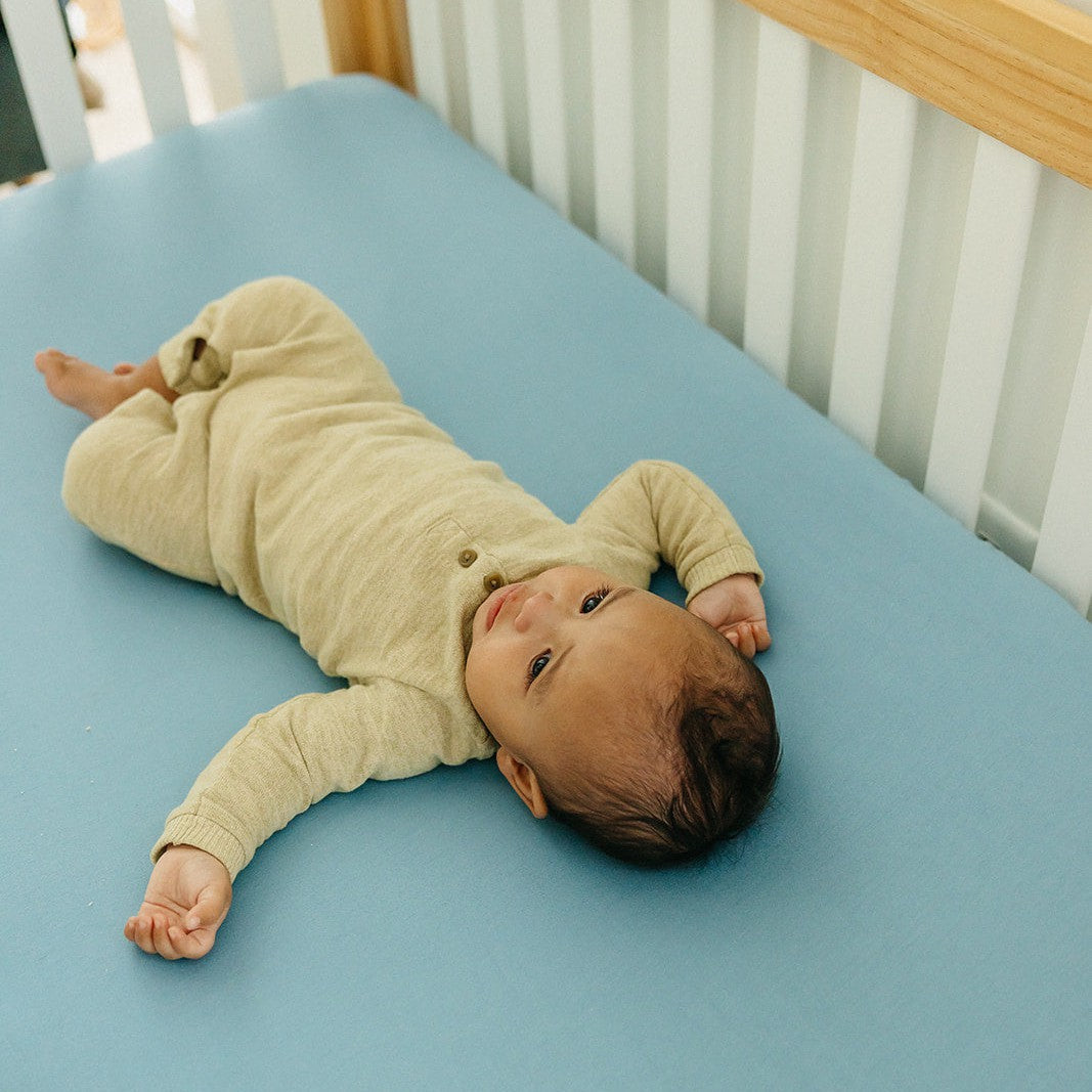 Copper Pearl Premium Knit Fitted Crib Sheet in Robin color, showing soft, snug-fitting fabric on a baby crib mattress.