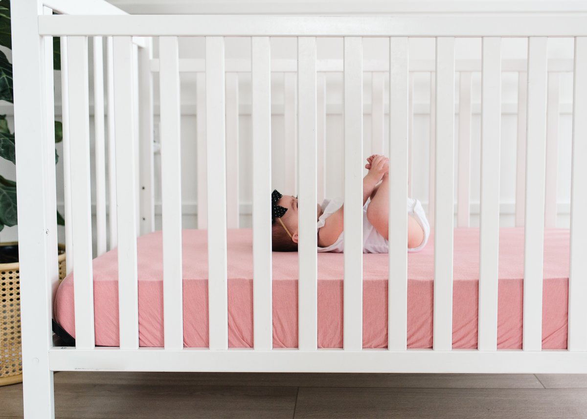 Copper Pearl Premium Knit Fitted Crib Sheet in soft fabric, shown on a crib mattress with snug fit and neat corners.